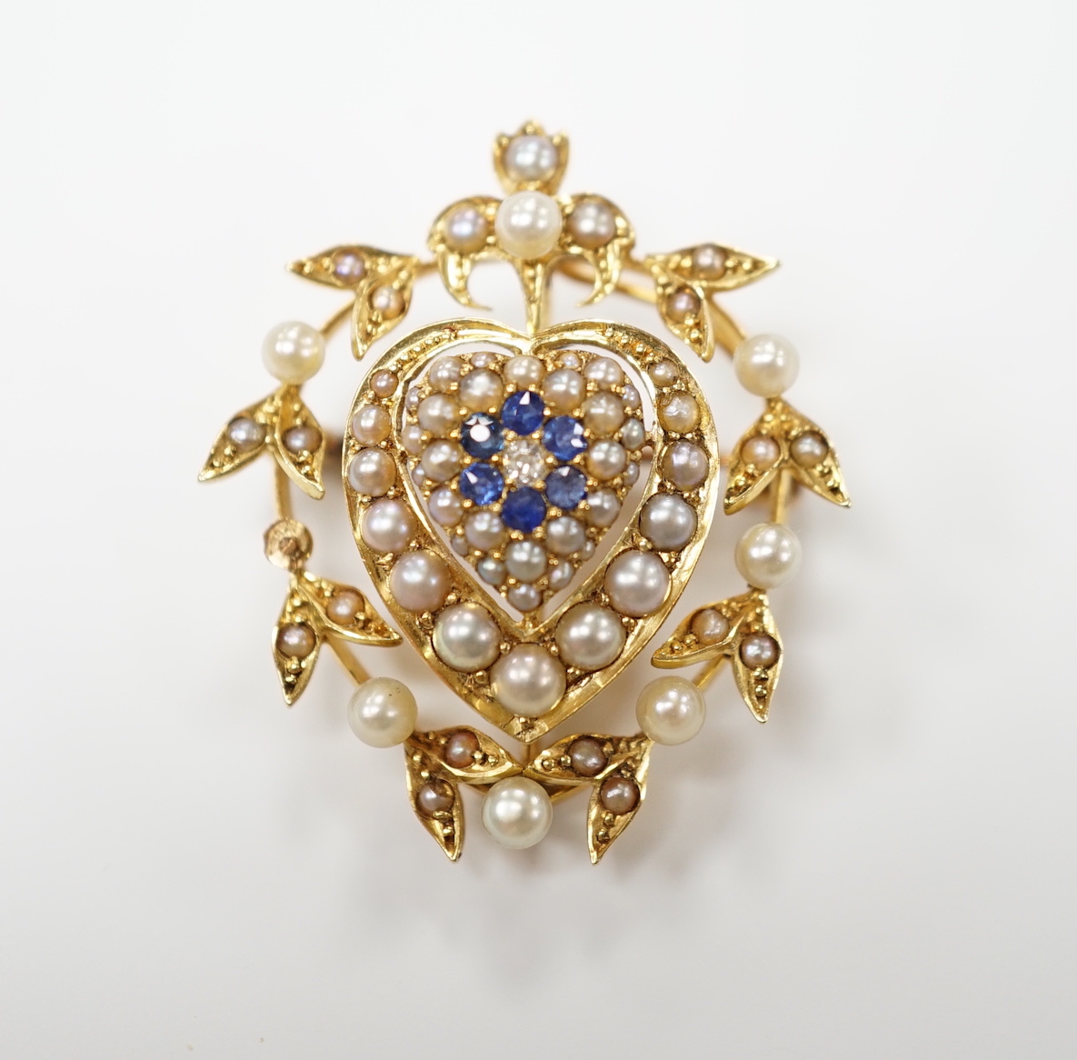 A yellow metal, sapphire, diamond and seed pearl set pendant brooch, with central heart motif, 30mm, gross weight 6.8 grams.